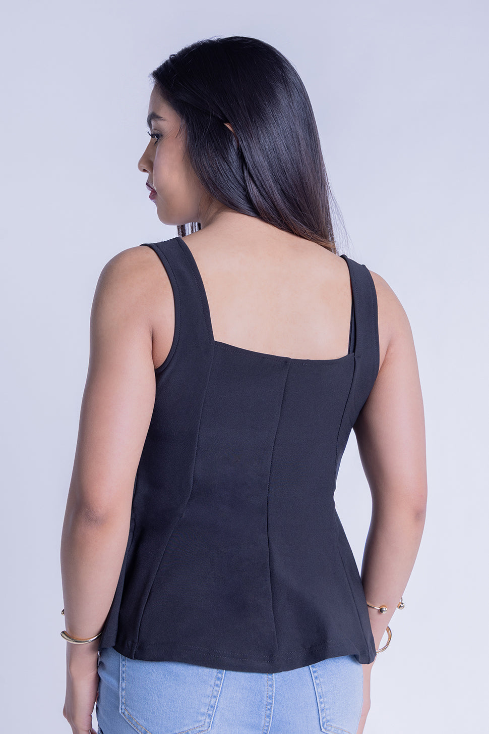 Blusa negra de tirantes seccionada con botones metalicos